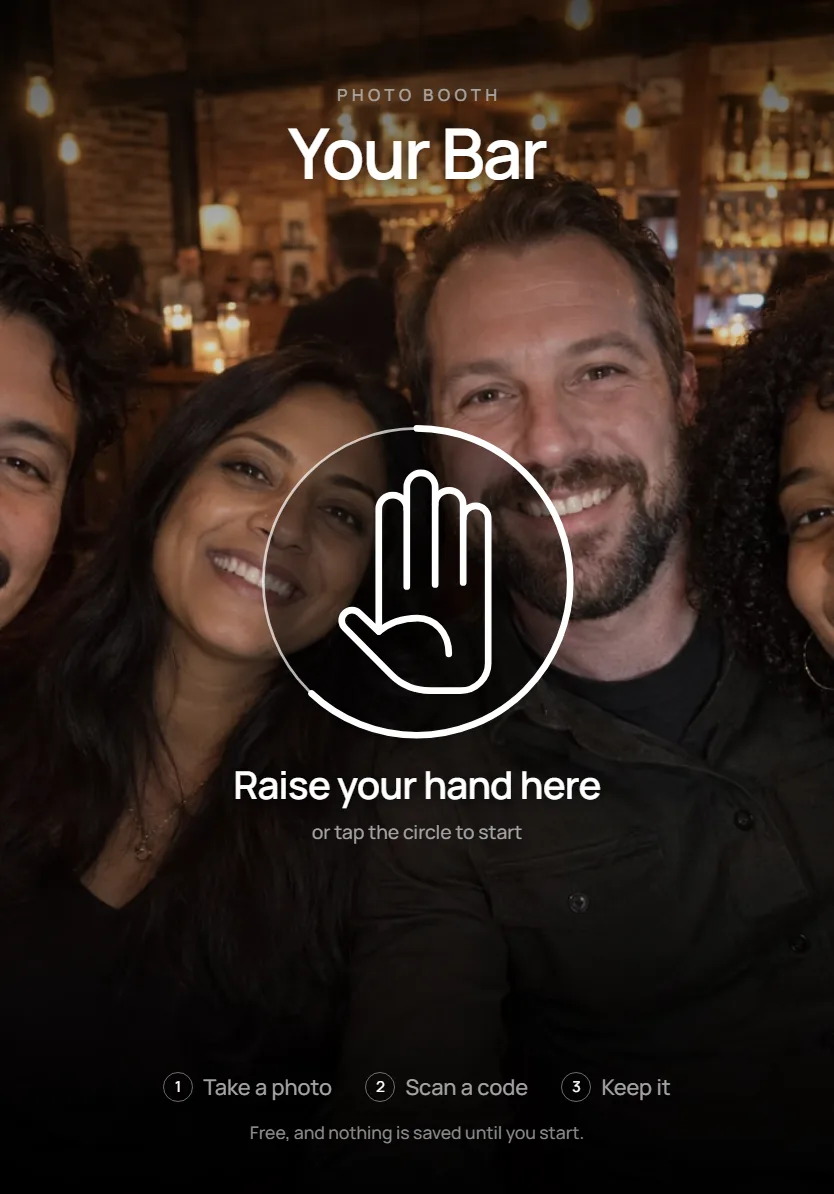 The booth's start screen: Your Bar in large type over the camera's view, a thin hand in a circle, and Raise your hand here
