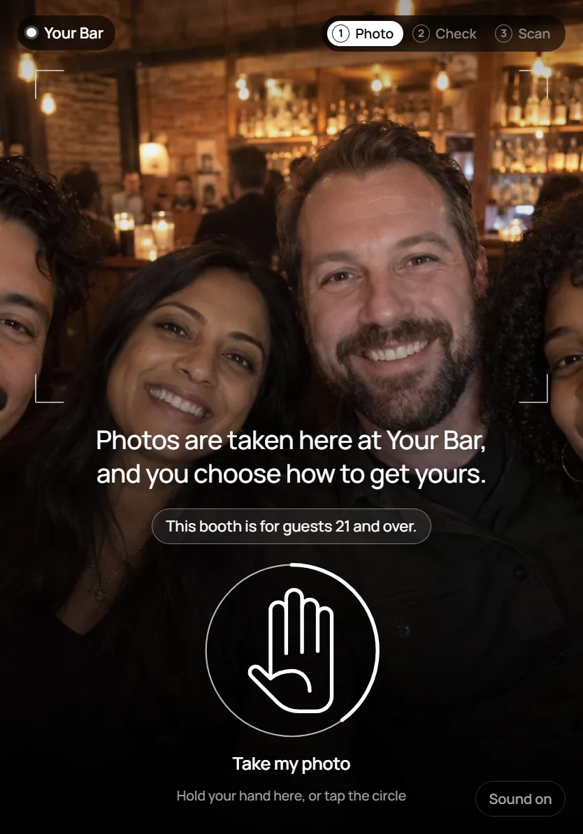 The booth's first screen after a hand is raised: one sentence saying photos are taken here and the guest chooses how to get theirs, over a Take my photo circle
